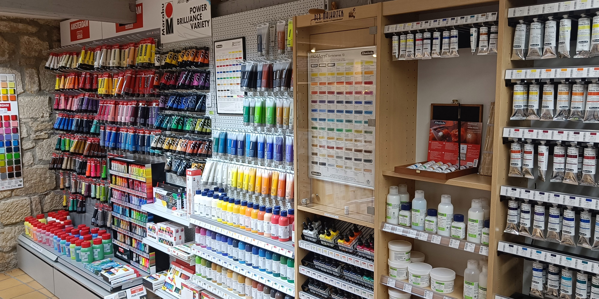 Unsere imposante Acrylfarbenwand erstrahlt in leuchtenden Farben. Die Wand zeigt eine Vielzahl von Farbtönen, sorgfältig angeordnet und übersichtlich sortiert.